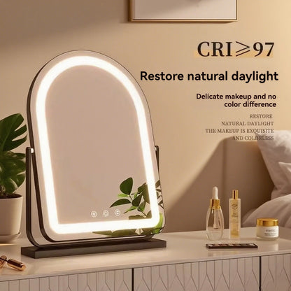 An arched LED vanity mirror with a black stand, illuminated with a warm white glow, set on a bedside table next to skincare products and a plant. Text overlays highlight and 'Restore natural daylight'.