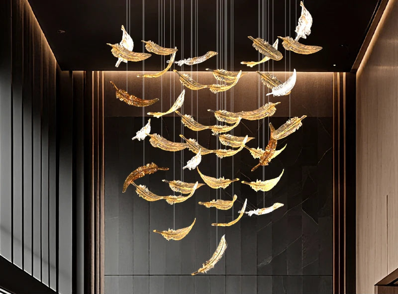Luxury chandelier with gold and white feathers hanging from the ceiling.